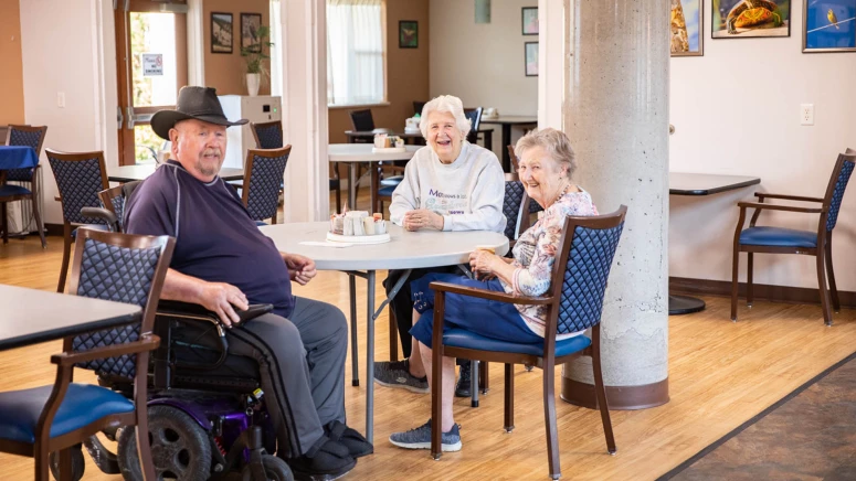 Several senior citizens sitting at Westsyde's dining area
