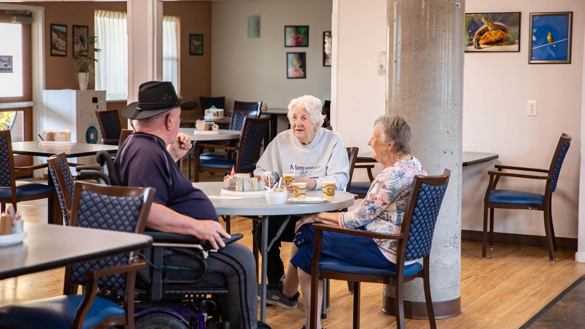 A group of senior citizens talking with each other while drinking coffee